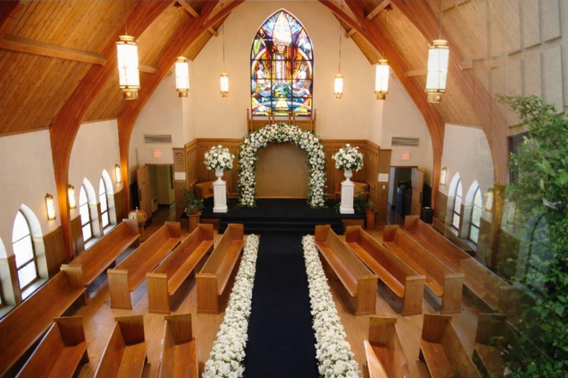 Chapel interior with wooden pews and stained glass windows
