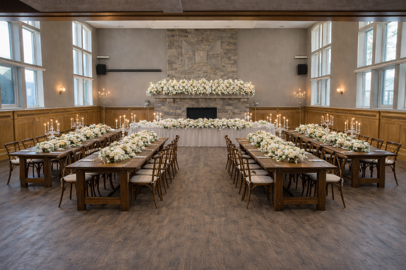 Rehearsal dinner with long harvest tables and floral head table