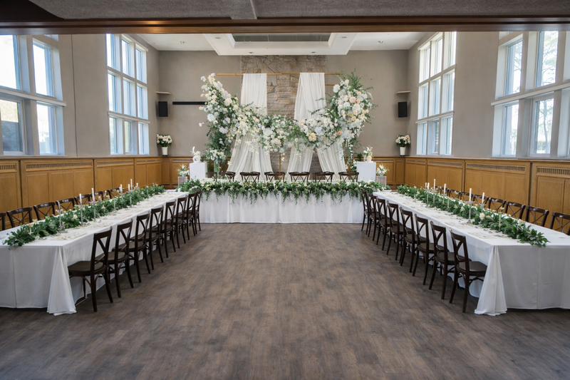 Hall elevated package — long head table with white floral backdrop
